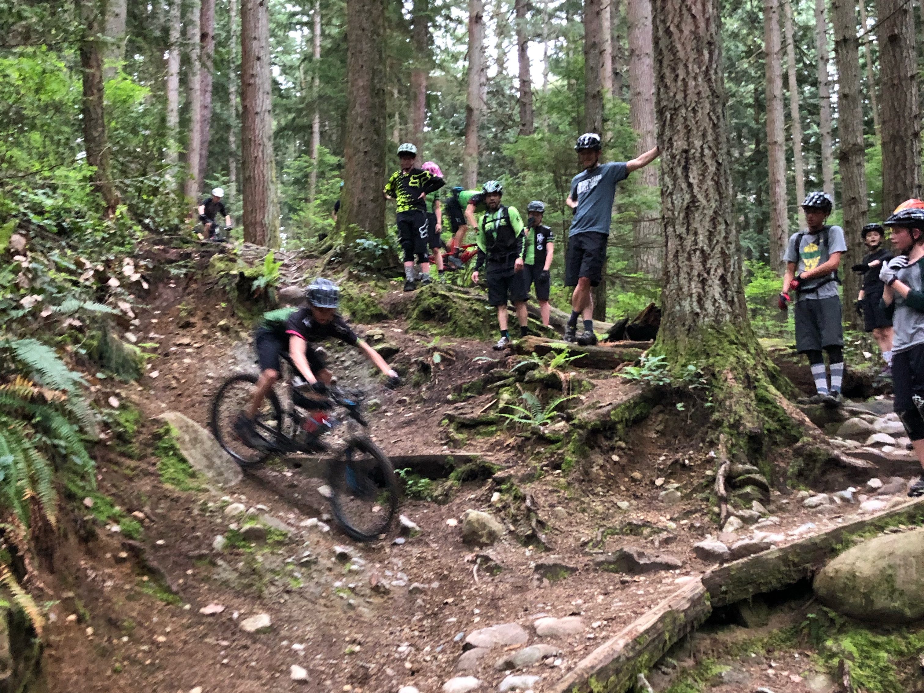 Tim Sherstobitoff coaching the Devo mountain bike team on the classic North Shore gnar. 